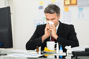 employee blowing nose at work