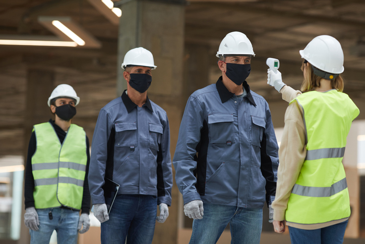 Construction workers having temperature checked due to covid