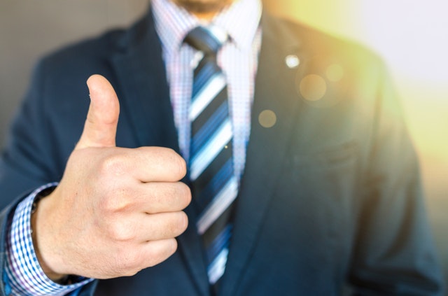 man in suit with thumb up