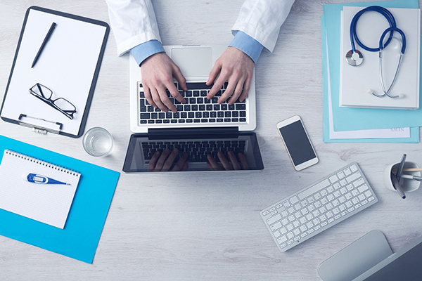 Doctor working on laptop - birds eye view